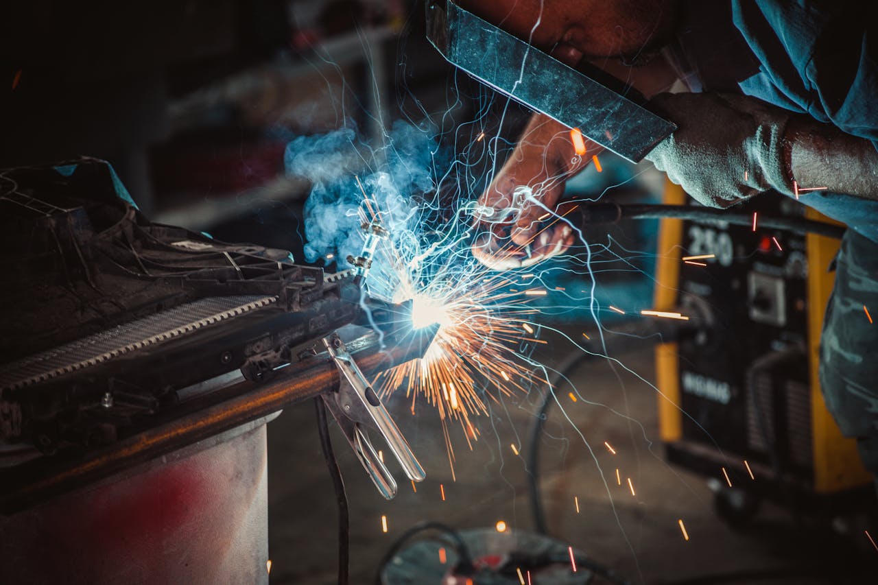 Intense close-up of a welder working on a project, showcasing sparks and safety equipment.