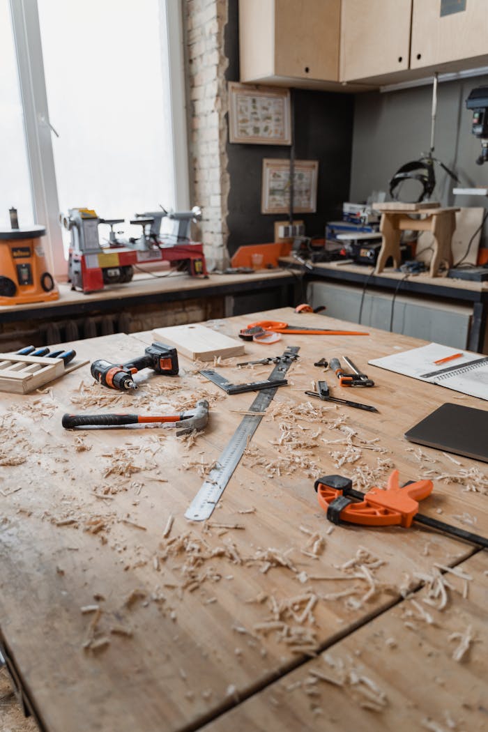 Various carpentry tools and wood shavings on a workshop table, capturing a busy work environment.